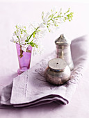 Silver salt and pepper shakers, flowers and a napkin