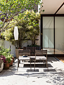 Open folding doors leading onto sunny terrace with seating area