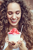 A young woman eating snow ice cream with strawberries