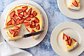 Strawberry Custard dessert cake with a knife and two serves on cake on plates
