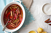 Rhubarb cooked with lemon in a white oval dish on a wooden serving board