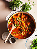 A tagine with peas, carrots, pepper, salt and parsley