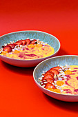 Peachy-Swirl-Bowl mit Erdbeeren, Physalis und Kokoschips