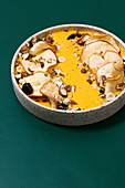 A winter smoothie bowl with sea buckthorn yoghurt and apple chips