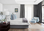 Elegant bedroom in pale blue, white and grey with ensuite bathroom