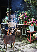 Feuerkorb vor Gartentischen mit Blumensträußen