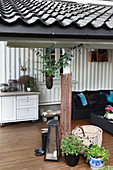 Sofa and rustic accessories on roofed terrace
