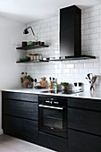 Modern, black fitted kitchen with white worksurface