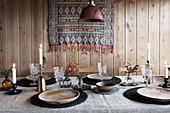 Dining table set with linen cloth, wooden plates and crystal glasses