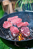 Raw beef loin steaks on a barbecue