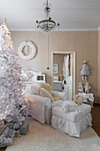 White Christmas tree and white loose-covered armchair with matching footstool