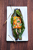 Grilled tofu with asparagus and cheese wrapped in a banana leaves