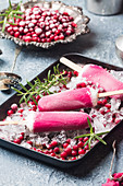 Pink cranberry popsicle with rosemary and berries