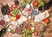 Antipasti-Buffet mit Wurst, Schinken, Käse, Gemüse, Beeren, Brot und Wein (Aufsicht)