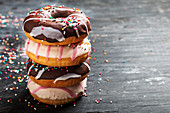 Stack of delicious donuts on black background
