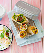 A wrap and a pitta pocket in a lunch box