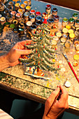 Hand-painted pewter Christmas tree in workshop