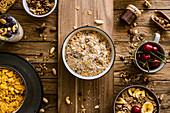 Muesli, cornflakes and fruit on a rustic wooden surface