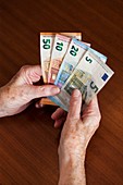 Elderly woman holding Euro banknotes