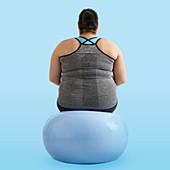 Overweight woman sitting on an exercise ball