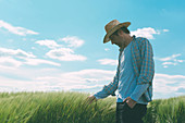 Farmer walking through green wheat field