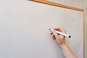 Female hand writing on whiteboard