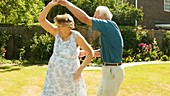 Elderly couple dancing in the garden