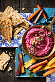 Beetroot hummus with rainbow carrots and toasted flat breads