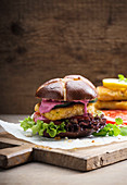 Vegan corn steak with vegetables and beetroot hummus in a lye roll
