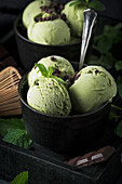 Matcha mint ice cream with chocolate chunks in a black bowl