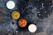Verschiedene Dips: Joghurt-Gurken-Sauce, Kichererbsen-Joghurt-Sauce, Romesco-Sauce und Remoulade