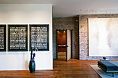 Three typographical artworks in modern loft apartment with brick walls