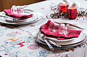 Gedeck mit roter Serviette auf weihnachtlicher Tischdecke