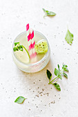 A fresh summer drink with limes, mint and fruit ice cubes