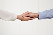 A man and a woman shaking hands (body language: loose handshake)