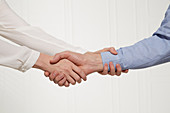 A woman holding a man's hand and his wrist (body language: possessive handshake)