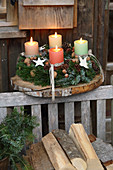 Rustikaler Adventskranz auf einer Holzscheibe