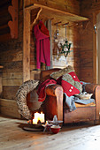 Vintage leather armchair and Christmas decorations in rustic wooden cabin