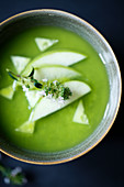 Matcha soup with green apples and cucumber in a bowl (top view)