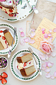 Romantic strawberry and rose layer cake on vintage plates with roses