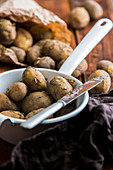 New potatoes in a sieve with a knife