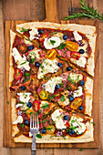 Pizza mit Mozzarella, Tomaten, Schinken, Heidelbeeren, Rosmarin, Oregano und Thymian