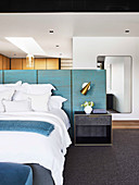Double bed and bedside table on blue panel as bed headboard and room divider in the bedroom
