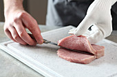 A pocket being cut in a pork escalope (cordon bleu)
