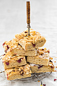 A stack of butter cake slices with pomegranate seeds and flaked almonds