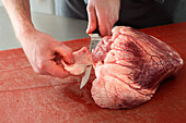 Beef heart being trimmed (fat and connective tissue being removed)