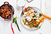 Kumpir (stuffed baked sweet potato) with spinach, carrot and red cabbage salad, raita and homemade chickpea noodles (India)