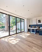 Table and corner bench in bright room with glass wall leading to terrace