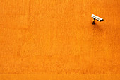 CCTV camera on orange wall