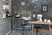 Rustic wooden table and sink on metal stand in black-and-white kitchen with various patterns